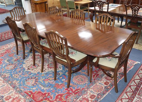 A set of eight Hepplewhite style mahogany dining chairs and a Regency mahogany two pillar dining table, with one spare leaf Table 290cm